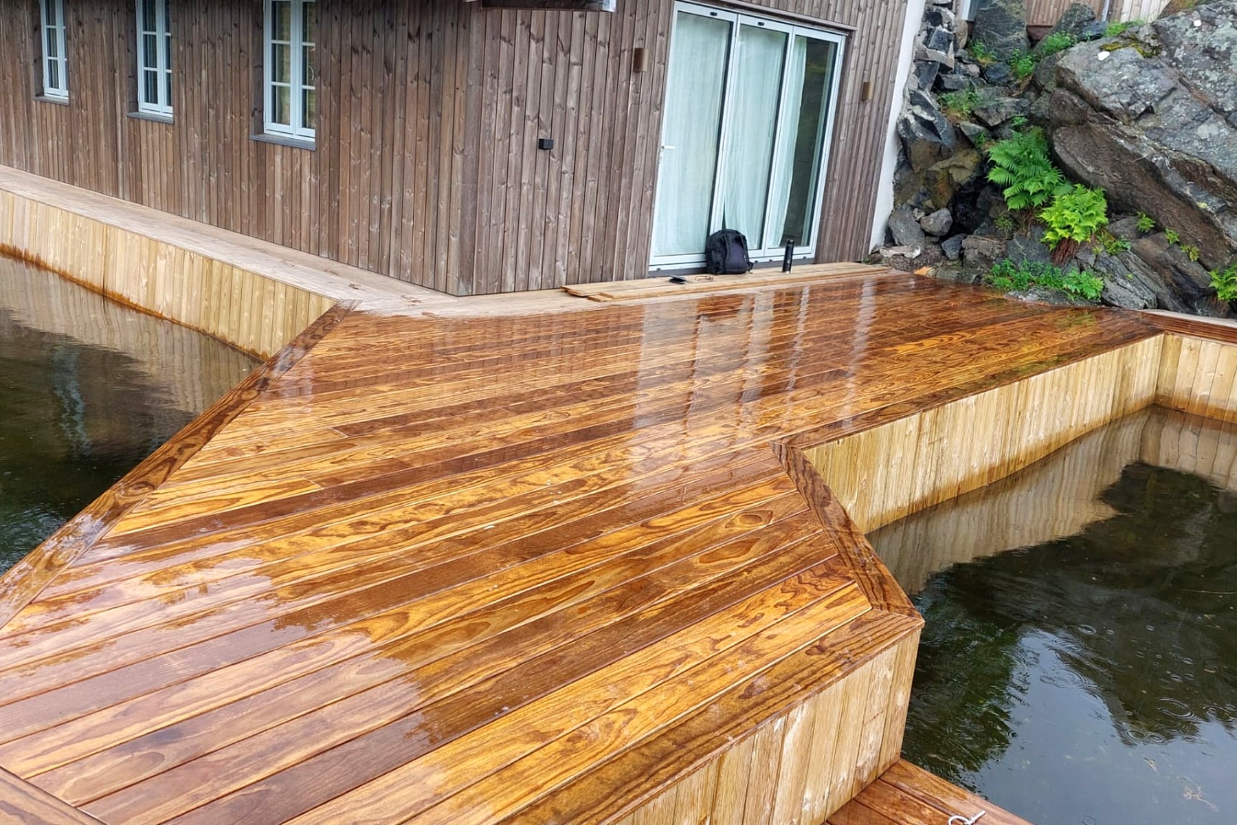 Vinklet trebrygge langs hyttevegg